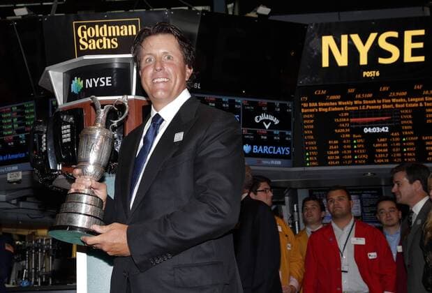 Phil Mickelson holds the Claret Jug when he stands on the floor of the New York Stock Exchange after he and executives from the Mickelson ExxonMobil Teachers Academy ring the closing bell at the NYSE on Wall Street In New York City on July 26, 2013. In its ninth year, the Mickelson ExxonMobil Teachers Academy is a week-long professional development program where third- through fifth-grade teachers hone their math and science skills and learn ways to excite and inspire their students in these subjects.  NYP20130726141
