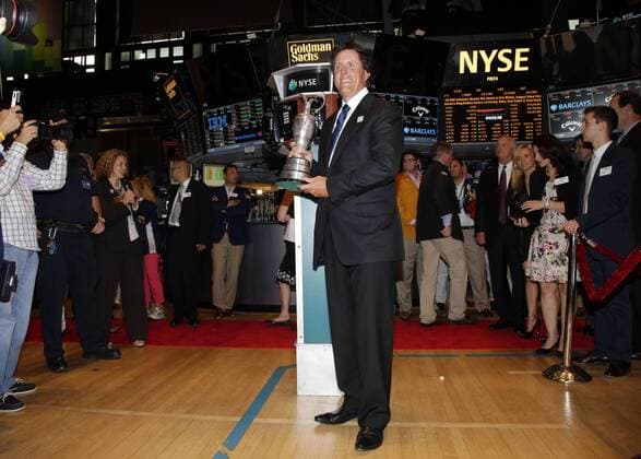 Phil Mickelson holds the Claret Jug when he stands on the floor of the New York Stock Exchange after he and executives from the Mickelson ExxonMobil Teachers Academy ring the closing bell at the NYSE on Wall Street In New York City on July 26, 2013. In its ninth year, the Mickelson ExxonMobil Teachers Academy is a week-long professional development program where third- through fifth-grade teachers hone their math and science skills and learn ways to excite and inspire their students in these subjects.  NYP20130726142