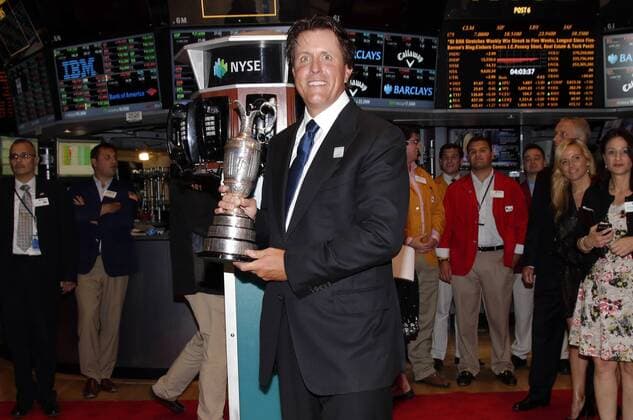 Phil Mickelson holds the Claret Jug when he stands on the floor of the New York Stock Exchange after he and executives from the Mickelson ExxonMobil Teachers Academy ring the closing bell at the NYSE on Wall Street In New York City on July 26, 2013. In its ninth year, the Mickelson ExxonMobil Teachers Academy is a week-long professional development program where third- through fifth-grade teachers hone their math and science skills and learn ways to excite and inspire their students in these subjects.  NYP20130726143
