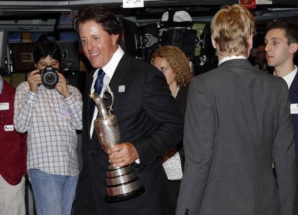 Phil Mickelson holds the Claret Jug when he walks on the floor of the New York Stock Exchange after he and executives from the Mickelson ExxonMobil Teachers Academy ring the closing bell at the NYSE on Wall Street In New York City on July 26, 2013. In its ninth year, the Mickelson ExxonMobil Teachers Academy is a week-long professional development program where third- through fifth-grade teachers hone their math and science skills and learn ways to excite and inspire their students in these subjects.  NYP20130726144