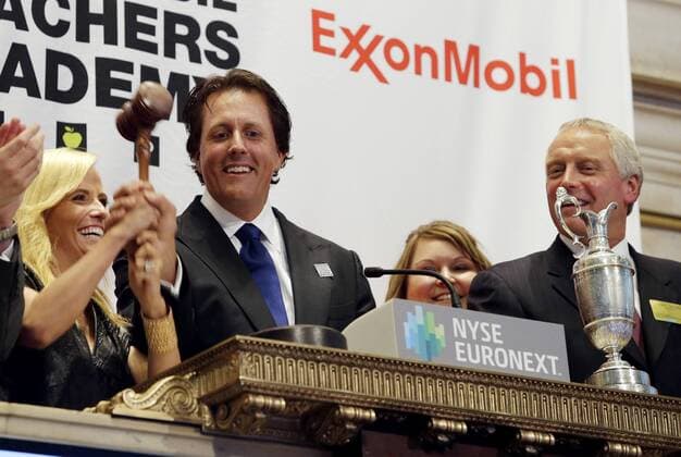 Phil Mickelson, Amy Mickelson and executives from the Mickelson ExxonMobil Teachers Academy stand with the Claret Jug when they ring the closing bell at the NYSE on Wall Street In New York City on July 26, 2013. In its ninth year, the Mickelson ExxonMobil Teachers Academy is a week-long professional development program where third- through fifth-grade teachers hone their math and science skills and learn ways to excite and inspire their students in these subjects.  NYP20130726146