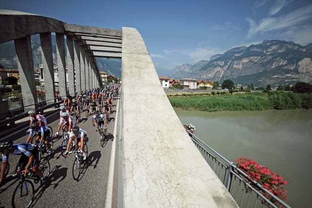 Das Fahrerfeld überquert eine Brücke - Aktion - quer - Event: 70. Tour de Pologne - Tour of Poland - Polen Rundfahrt 2013 - 2.Etappe: Marilleva Vale di Sole nach Passo di Pordoi Val di Fassa 206.5 km - Location: Italien - Europa - Datum: 28.07.2013