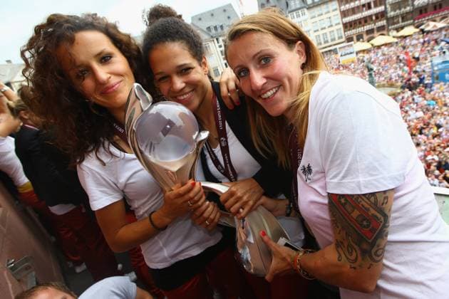 FRANKFURT AM MAIN, GERMANY - JULY 29: (L-R) Fatmire Bajramaj, Celia Okoyino da Mbabi and Anja Mittag of Germany lift the trophy after winning the UEFA Women s EURO 2013 on the balcony of the Römer on July 29, 2013 in Frankfurt am Main, Germany. Local Caption Fatmire Bajramaj; Celia Okoyino da Mbabi; Anja Mittag
