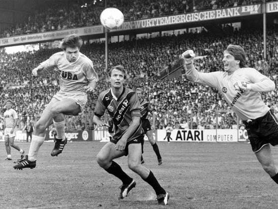 Bernhard Raab (Karlsruher SC) gegen Karl Heinz -Charly- Körbel und Torwart Uli Stein (beide Eintracht Frankfurt)