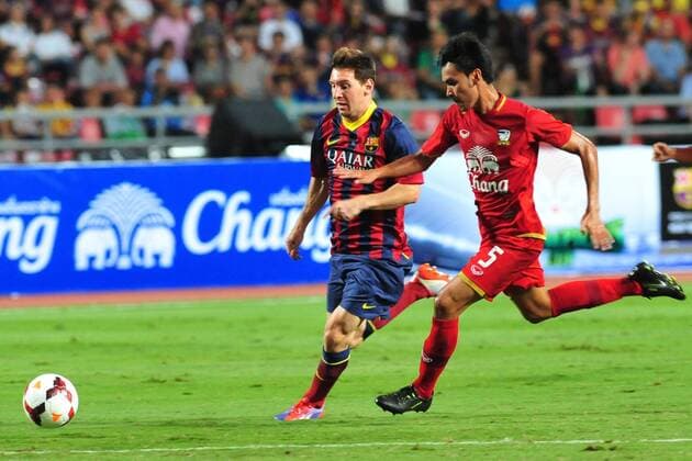 BANGKOK, Aug. 7, 2013 -- Lionel Messi (L) of Barcelona vies for the ball during a friendly match against Thailand s National team in Bangkok, Thailand, Aug. 7, 2013. Barcelona won 7-1. (Xinhua Rachen Sageamsak) (SP)THAILAND-BANGKOK-SOCCER-BARCELONA 