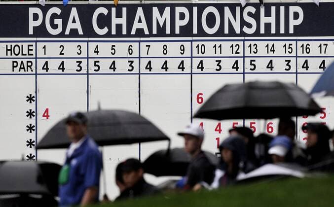 Spectators watch the action on the 18th green while holding umbrellas in the rain in the second round of the PGA Golf Herren Championship at Oak Hill Country Club in Rochester, New York on August 9, 2013.  NYP20130809101