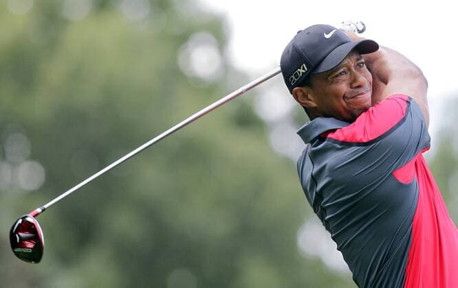 Tiger Woods hits a tee shot on the 4th hole in the final round of the PGA Golf Herren Championship at Oak Hill Country Club in Rochester, New York on August 11, 2013.  NYP20130811104