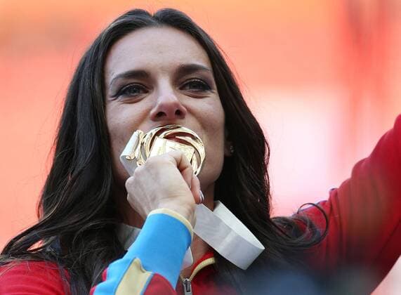 ITAR-TASS: MOSCOW, RUSSIA. AUGUST 15, 2013. Gold medal winner, Russia s Yelena Isinbayeva kisses her medal during the medal ceremony for the women s pole vault final at Luzhniki on Day 6 of the 14th IAAF World Championships in Athletics.  premiumd RE12570E