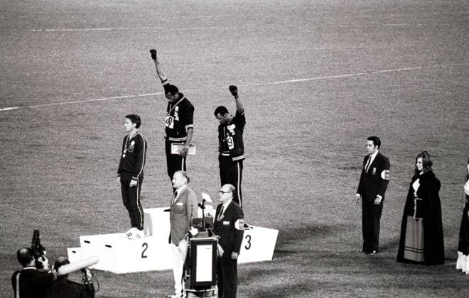Ikonische Bilder der Sportgeschichte 1968 Olympic Games, Mexico City America s gold and bronze medallists Tommie Smith (centre) and John Carlos (right) raise their arms as a Black Power gesture during the Olympic Awards Ceremony. Smith had set a world record of 19.8 seconds in the 200 metre race. Each man wore a black glove on one hand and raised it, with fist clenched as the US flag was raised. Perter Norman from Australia (left) won the silver medal. 16th October 1968.  UnitedArchives00562801