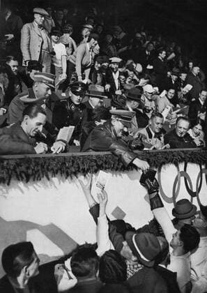 The Fuhrer and Chancellor Adolf Hitler giving autographs to the Canadian crew in the ice skating stadium in the Garmisch-Partenkirchen region. Â  UnitedArchives00797744