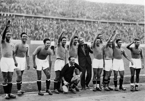 1936 Olympics, Berlin - Italian football team giving a victory salute after the final game of the tournament - 2:1 against Austria. (Italiens Olympiasieg im Fussball-Turnier wurde von einer jungen Studentenmannschaft errungen, die im Endspiel Osterreich mit 2 : 1 schlug.) Â  UnitedArchives00865006