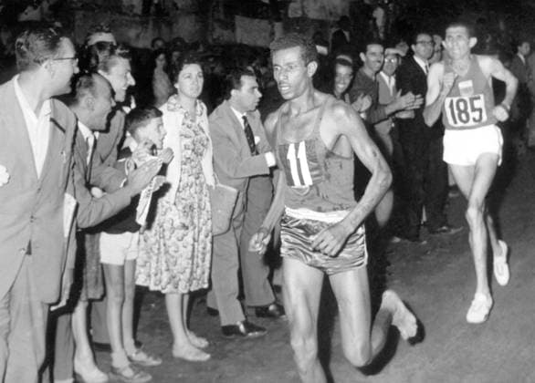 To the cheers of a huge crowd in Rome, Bikila Abebe of Ethopia (11) runs barefooted up to the finishing line to win the 26 mile marathon of the 1960 Olympic games, in a record time of 2 hours 15 minutes 16.2 seconds. He was closely followed by Abdesian Rhadi of Morocco (185). The two had been the only ones in the race with a chance of winning on the halfway mark 10th September 1960.  UnitedArchives00955553