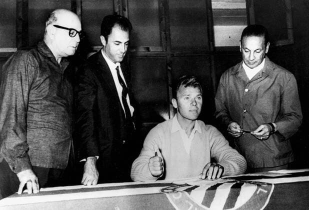 9th September 1963: Long time ace of Spanish football, Ladislao Kubala (seated) is pictured here, as he signs up for Barcelona s El Espanol. Team officials look on.  UnitedArchives01009701