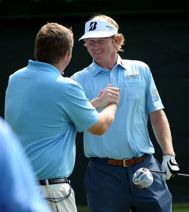 Defending champion Brandt Snedeker (R) greets an acquaintance on hole No. 1 during practice for the PGA Golf Herren Tour Championship on September 17, 2013 at East Lake Golf Club in Atlanta. The 30 top players are competing for a chance to win the $10 million FedExCup.  AJP2013091707
