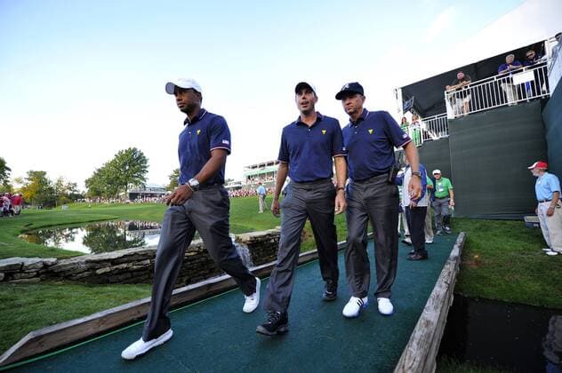 United States Team member Tiger Woods (L-R), Matt Kuchar and captain s assistant Davis Love III walk off the 14th hole during the fourball matches against the International Team at the 2013 Presidents Cup at Muirfield Village Golf Club in Dublin, Ohio on October 3, 2013. After Thursday s matches, the United States leads 3.5 to 2.5 points.  BKX2013100361