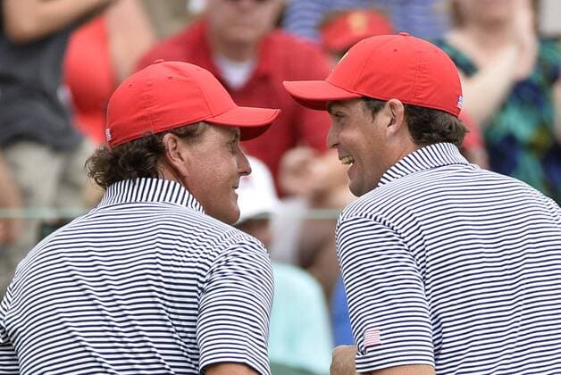 United States Team member Keegan Bradley (R) congratulates teammate Phil Mickelson after Mickelson made an eagle putt on the fifth hole during the second round foursome competition against the International Team at the 2013 Presidents Cup at Muirfield Village Golf Club in Dublin, Ohio on October 4, 2013.  BKX2013100425
