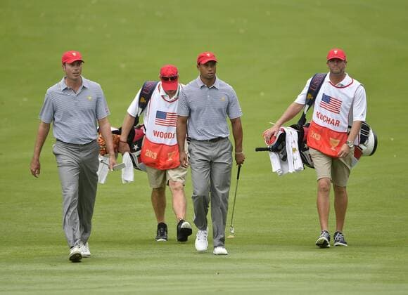 United States Team members Tiger Woods (C) and Matt Kuchar (L) walk up the fifth fairway during the second round foursome competition against the International Team at the 2013 Presidents Cup at Muirfield Village Golf Club in Dublin, Ohio on October 4, 2013.  BKX2013100432