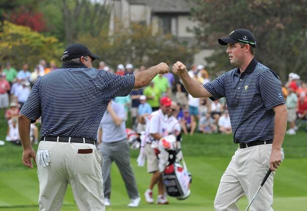 International Team member Angel Cabrera of Argentina (L) congratulates teammate Marc Leishman of Australia after Leishman sunk a birdie putt on the fifth hole during the second round foursome competition against the United States Team at the 2013 Presidents Cup at Muirfield Village Golf Club in Dublin, Ohio on October 4, 2013.  BKX2013100440