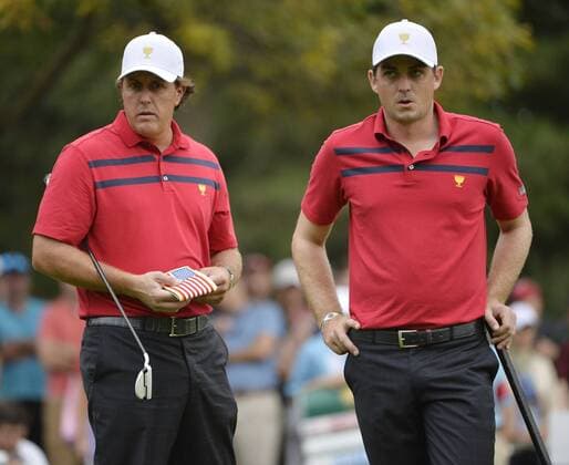 United States Team member Phil Mickelson (L) and teammate Keegan Bradley stand on the sixth green during the third round four-ball competition against the International Team at the 2013 Presidents Cup at Muirfield Village Golf Club in Dublin, Ohio on October 5, 2013.  BKX2013100514