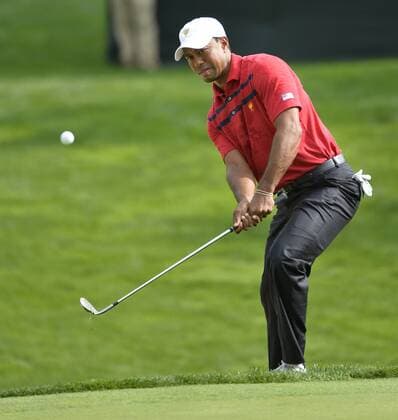 United States Team member Tiger Woods chips onto the sevent hole during the third round four-ball competition against the International Team at the 2013 Presidents Cup at Muirfield Village Golf Club in Dublin, Ohio on October 5, 2013.  BKX2013100536