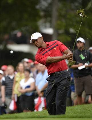 United States Team member Tiger Woods chips onto the eighth green during the third round four-ball competition against the International Team at the 2013 Presidents Cup at Muirfield Village Golf Club in Dublin, Ohio on October 5, 2013.  BKX2013100549