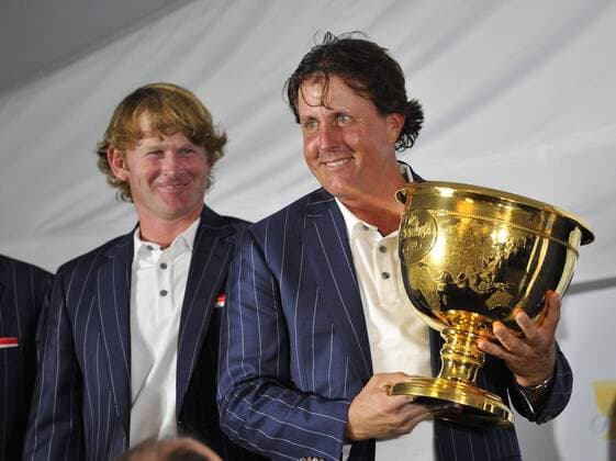 United States Team member Phil Mickelson (R) holds the Presidents Cup as Brandt Snedeker watches during a news conference following the 2013 Presidents Cup at Muirfield Village Golf Club in Dublin, Ohio on October 6, 2013. The United States defeated the International Team 18.5 to 15.5 to retain the Presidents Cup.  BKX2013100632