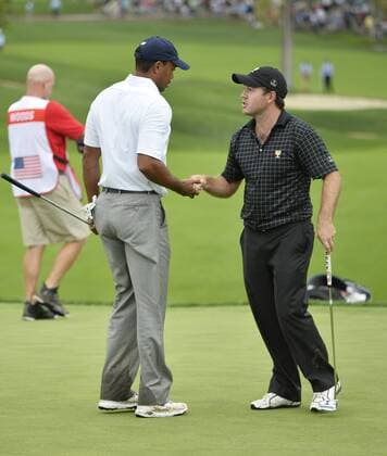 United States Team member Tiger Woods (L) gets a ball from International Team member Richard Sterne of South Africa on the 18th green after defeating him 1up during the fifth round singles competition at the 2013 Presidents Cup at Muirfield Village Golf Club in Dublin, Ohio on October 6, 2013. Woods win secured the United States victory. The United States defeated the International Team 18.5 to 15.5 to retain the Presidents Cup.  BKX2013100619