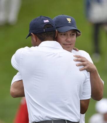 United States Team members Tiger Woods and Jason Dufner embrace on the 18th green after Woods defeated International Team member Richard Sterne of South Africa 1-up to win his match and clinch a U.S. victory during the fifth round singles competition at the 2013 Presidents Cup at Muirfield Village Golf Club in Dublin, Ohio on October 6, 2013. The United States defeated the International Team 18.5 to 15.5 to retain the Presidents Cup.  BKX2013100625