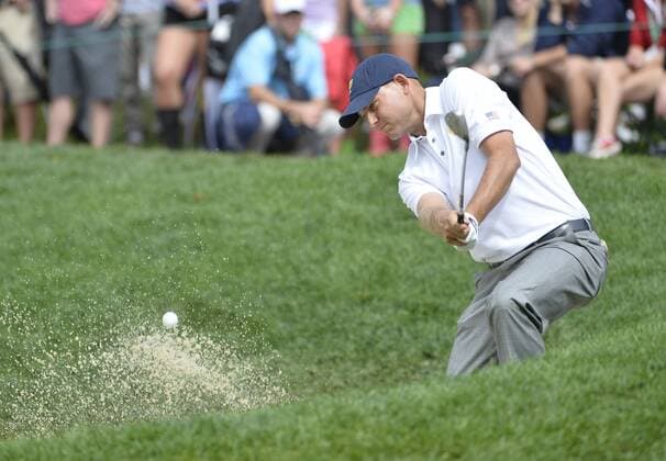 United States Team member Bill Haas chips out of of a bunker and onto the 14th green during the fifth round singles competition against the International Team at the 2013 Presidents Cup at Muirfield Village Golf Club in Dublin, Ohio on October 6, 2013. The United States defeated the International Team 18.5 to 15.5 to retain the Presidents Cup.  BKX2013100646
