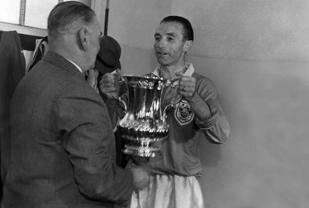 Football - 1953 FA Cup Final - Blackpool 4 Bolton Wanderers 3 Blackpool s Stanley Matthews passes the trophy to manager Joe Smith in the changing rooms at Wembley. 02 05 1953 