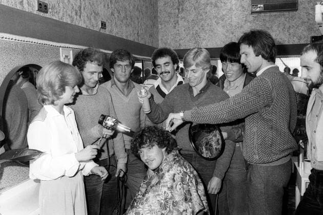 Eintracht Frankfurt beim Friseur - Wolfgang Trapp bekommt die Haare schön, dahinter v.li.: Bernd Hölzenbein mit Fön, Werner Lorant, Fred Schaub, Norbert Nachtweih mit Haarspray, Bum Kun Cha, Karl Heinz -Charly- Körbel mit Spiegel, Horst Ehrmantraut
