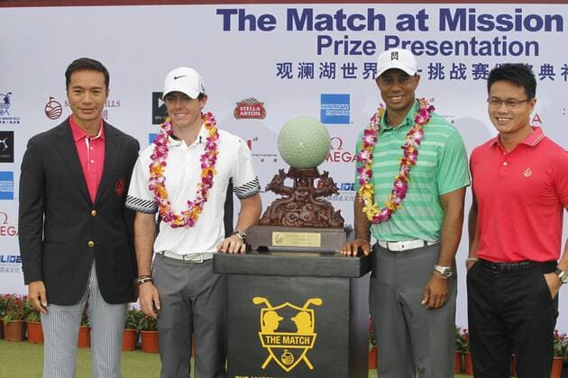 Rory McIlroy of Northern Ireland, second left, and Tiger Woods of the United States, second right, pose with the champion trophy at the award ceremony of The Match at Mission Hills in Haikou city, south Chinas Hainan province, 28 October 2013. Rory McIlroy finally tasted success for the first time this year when he beat an ailing Tiger Woods by one shot in a megabucks exhibition match in China on Monday (28 October 2013). McIlroy roars against Tiger in China  pau902585_22