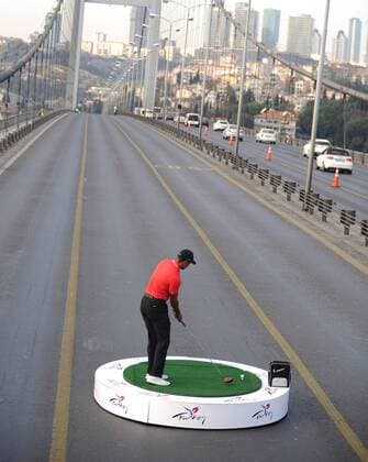 U.S. golfer Tiger Woods hits a ball as he poses during an event to promote the upcoming Turkish Airlines Open golf tournament, on the Bosphorus Bridge that links the city s European and Asian sides, in Istanbul, on November 5, 2013. Woods is in Turkey to attend the tournament, which will take place in Antalya, southern Turkey, between November 7 to 10, 2013. 