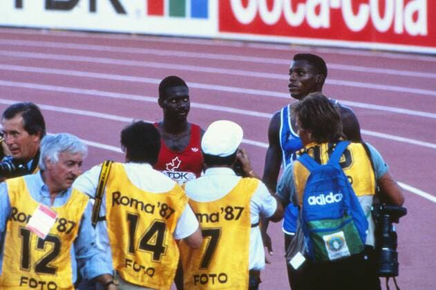 Athletics - 1987 IAAF Rome World Championships - Men s 100m Final Photographer mob Canada s Ben Johnson (red) and the USA s Carl Lewis (in blue) after Johnson had sensationally defeated Lewis and set a new World Record of 9.83s at the Stadio Olimpico. 30 08 1987 