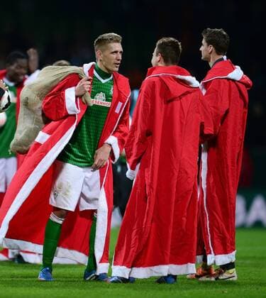 FUSSBALL 1. BUNDESLIGA SAISON 2013 2014 17. SPIELTAG SV Werder Bremen - 21.12.2013 Nils Petersen, Philipp Bargfrede und Sebastian Mielitz (v.l., alle SV Werder Bremen) haben sich jeweils ein Weihnachtsmann-Kostüm angezogen 