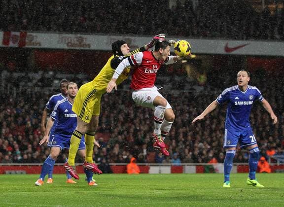 Arsenal s Mesut Ozil tussles with Chelsea s Petr Cech Arsenal vs Chelsea - Premier League - Emirates Stadium - London - England - 23 12 2013 - Pic David Klein Sportimage EDITORIAL USE ONLY. No use with unauthorised audio, video, data, fixture lists, club league logos or live services. Online in-match use limited to 120 images, no video emulation. No use in betting, games or single club league player publications.