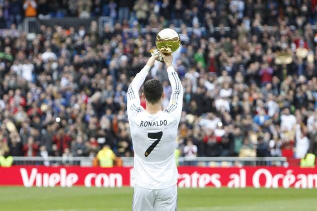 Real Madrid s Cristiano Ronaldo holds the Ballon d or trophy before the Spanish league football match Real Madrid vs FC Granada in Santiago Bernabeu stadium in Madrid, Spain. January 25, 2014.  (2014012510356)