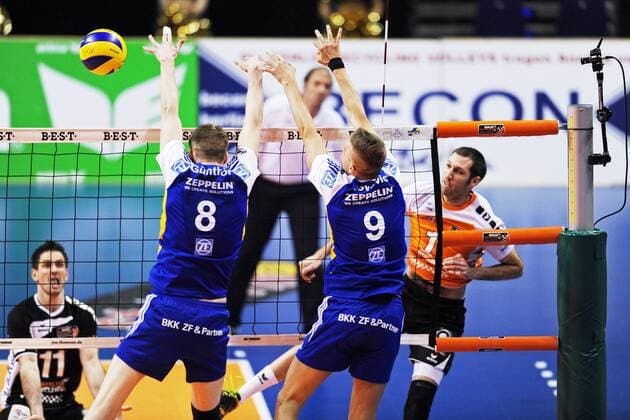 Scott TOUZINSKY ( USA 1 Berlin Volleys ) setzt sich am Netz gegen Max GÜNTHÖR ( GER 8 ) und Nikola JOVOVIC ( SRB 9 beide VfB Friedrichshafen ) durch - Spielszene - Aktion - Querformat - quer - horizontal - Event: Berlin Recycling Volleys vs. VfB Friedrichshafen - DVL Deutsche Volleyball Liga - Saison 2013 14 - 12.Spieltag - Location: Max Schmeling Halle Berlin - Deutschland - Europa - Datum: 02.02.2014