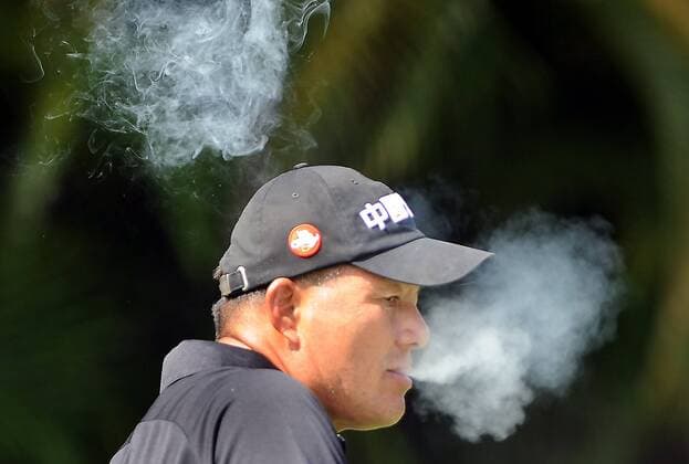 Feb. 9, 2014 - Boca Raton, FL, USA - Chien Soon Lu lets out two lungs worth of smoke as he lights up on the 7th tee during the Allianz Championship at The Old Course at Broken Sound in Boca Raton, Fla., on Sunday, Feb. 9, 2014. SPORTS GLF-ALLIANZ - ZUMAm67