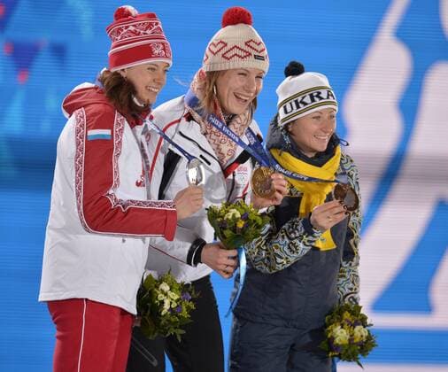 Russia s Olga Vilukhina (L-R), Slovokia s Anastasiya Kuzmina, and Ukraine s Vita Semerenko hold their silver, gold and bronze medals during the victory ceremony for the Biathalon Women s Sprint at the Sochi 2014 Winter Olympics on February 10, 2014 in Sochi, Russia.  OLY20140210133