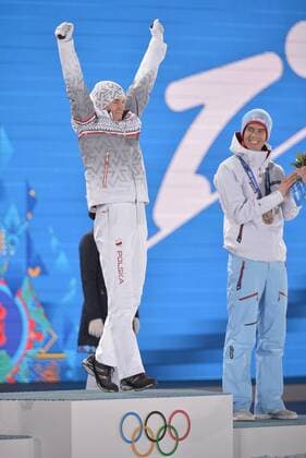 Poland s Kamil Stoch (L) celebrates before he is awarded a gold medal as Norway s Anders Bardal, bronze medalist, applauds during the victory ceremony for men s individual normal hill ski jumping at the Sochi 2014 Winter Olympics on February 10, 2014 in Sochi, Russia.  OLY20140210138