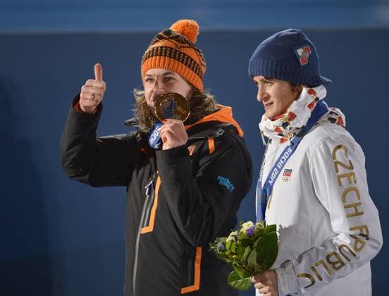 The Netherland s Ireen Wüst (L) holds up her gold medal as she stands with The Czech Republic s Martina Sablikova, who won a silver after the victory ceremony for ladies 3000M speed skating at the Sochi 2014 Winter Olympics on February 10, 2014 in Sochi, Russia.  OLY20140210165