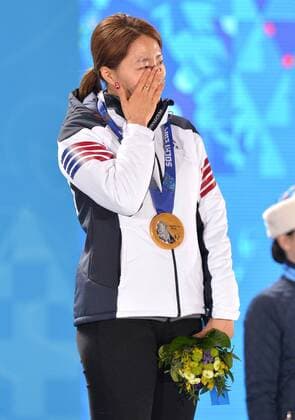 Gold medalist, South Korea s Sang Hwa Lee, wipes tears from her face as the South Korean national anthem is played during the victory ceremony for the ladies speed skating 500m at the Sochi 2014 Winter Olympics on February 12, 2014 in Sochi, Russia.  OLY20140212346