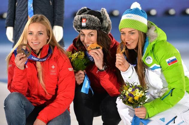 Tying gold medalist, Switzerland s Dominique Gisin (center) and Slovakia s Time Maze pose with bronze medalist Switzerland s Lara Gut during the victory ceremony for ladies downhill, at the Sochi 2014 Winter Olympics on February 12, 2014 in Sochi, Russia.  OLY20140212363