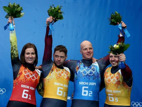 ITAR-TASS: SOCHI, RUSSIA. FEBRUARY 14, 2014. Bronze medalists, Latvia s Eliza Tiruma, Martins Rubenis, Andris and Juris Sics (L-R) pose at a flower ceremony following the Luge Team Relay competition at the 22nd Winter Olympic Games in Sochi, at the Sanki Sliding Center.  RE1392C0