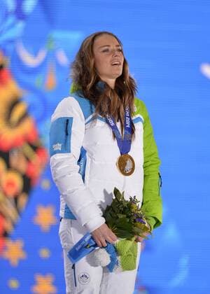 Slovenia s Tina Maze stands for the playing of the Slovenian national anthem during the victory ceremony for ladies alpine skiing giant slalom at the Sochi 2014 Winter Olympics on February 19, 2014 in Sochi, Russia. Maze won a gold medal in the event.  OLY20140219122