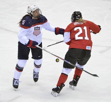 United States Anne Schleper (L) and Canada s Haley Irwin go for the puck during the first period of the women s gold medal ice hockey game at the Sochi 2014 Winter Olympics on February 20, 2014 in Sochi, Russia.  OLY20140220128
