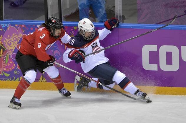 Canada s Jocelyne Larocque (L) and United States Alex Carpenter go for the puck during the second period of the women s gold medal ice hockey game at the Sochi 2014 Winter Olympics on February 20, 2014 in Sochi, Russia.  OLY20140220133