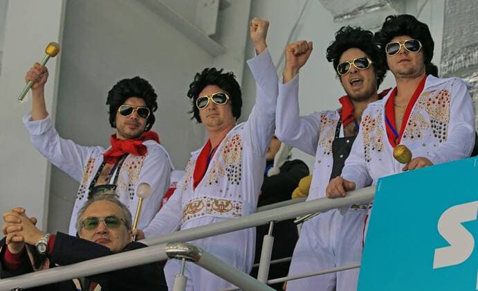 ITAR-TASS: SOCHI, RUSSIA. FEBRUARY 20, 2014. Sports fans dressed as Elvis Presley watch the women s curling final game Canada vs. Sweden during the 22nd Winter Olympic Games in Sochi.  Aufmacher premiumd kurios RE13A642