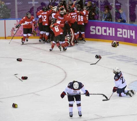 United States Anne Schleper (L) and Michelle Picard react as Canada celebrates after defeating the United States to win the women s ice hockey game at the Sochi 2014 Winter Olympics on February 20, 2014 in Sochi, Russia. Canada won 3-2 in overtime.  OLY20140220148